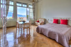 Pièce principale donnant sur le balcon loggia avec vue panoramique sur la ville et le lac - résidence Excelsior